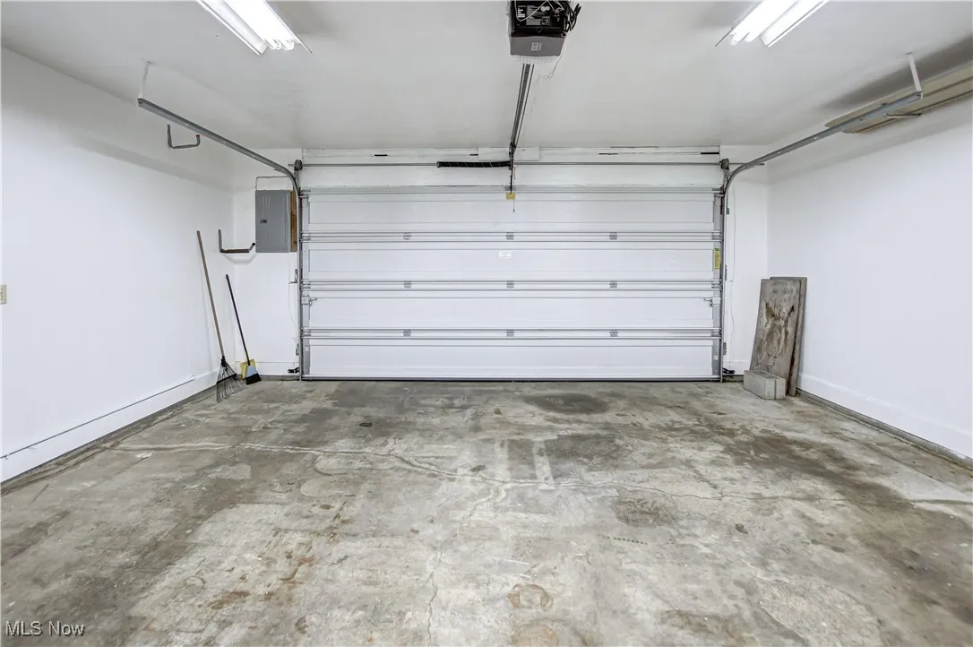 Garage featuring a garage door opener and electric panel