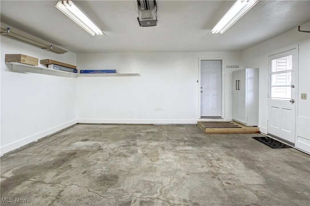 Garage featuring freestanding storage cabinet and a garage door opener
