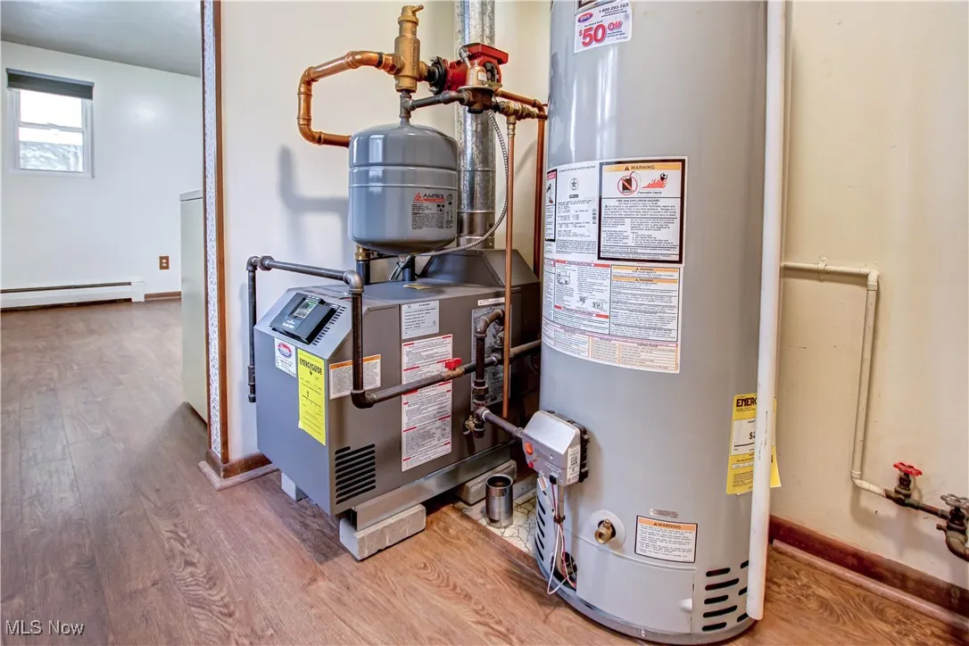 Utility room featuring water heater and gas hot water/boiler heating system