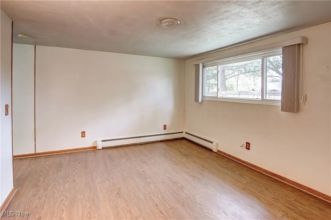 Living room with light wood-style laminate flooring and a textured ceiling