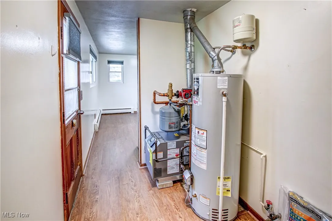 Utility room featuring gas water heater and a hot water/boiler heating unit
