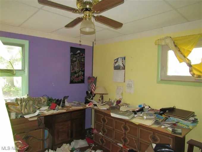 Home office featuring a drop ceiling and a ceiling fan