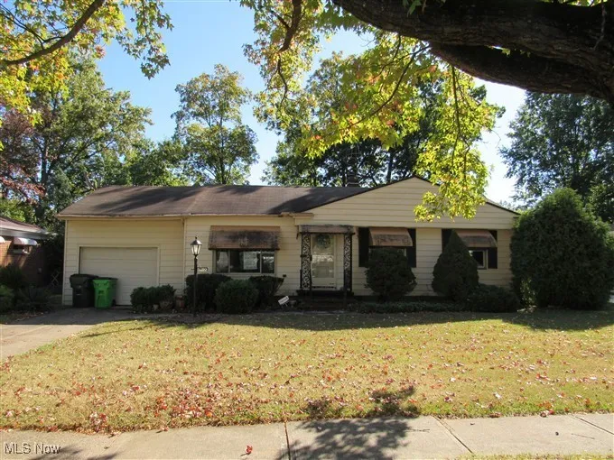 Single story home featuring a front yard, an attached garage, and concrete driveway