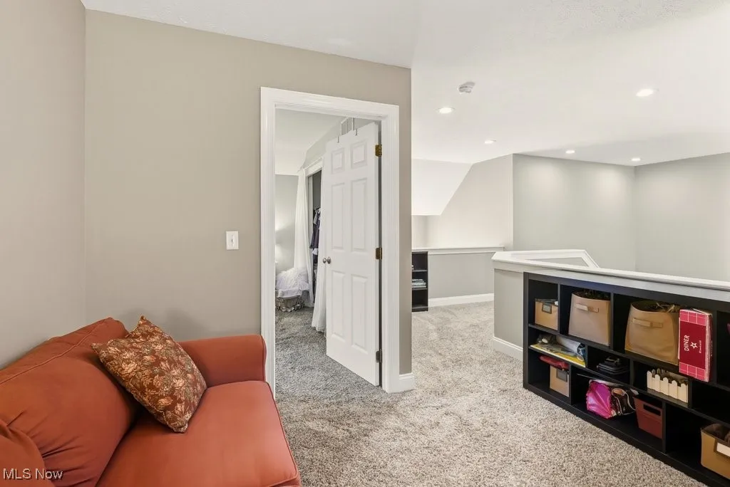 Sitting room featuring light colored carpet, recessed lighting, and an upstairs landing