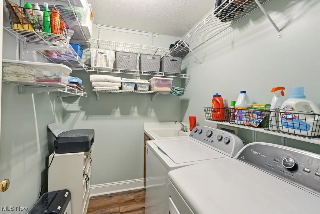 Laundry area featuring dark wood-style flooring, a textured ceiling, and washer and dryer