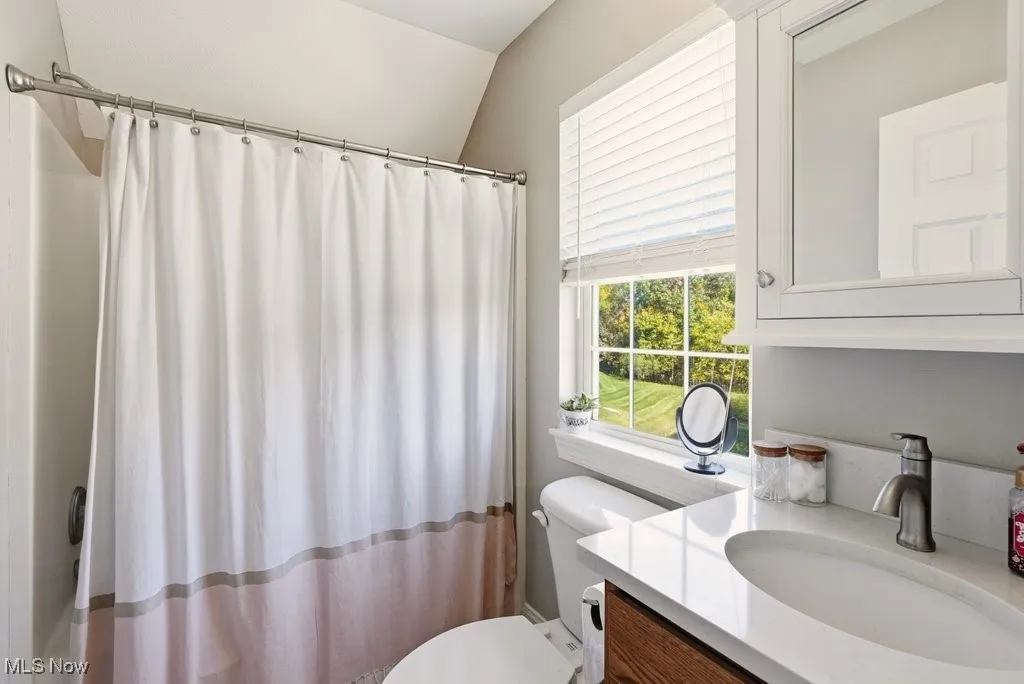 Full bath with vanity and curtained shower
