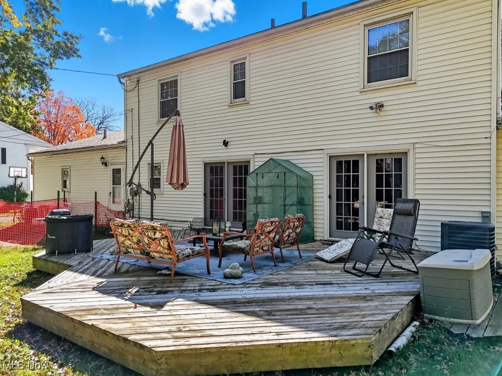 Rear view of house with a wooden deck and an outdoor hangout area