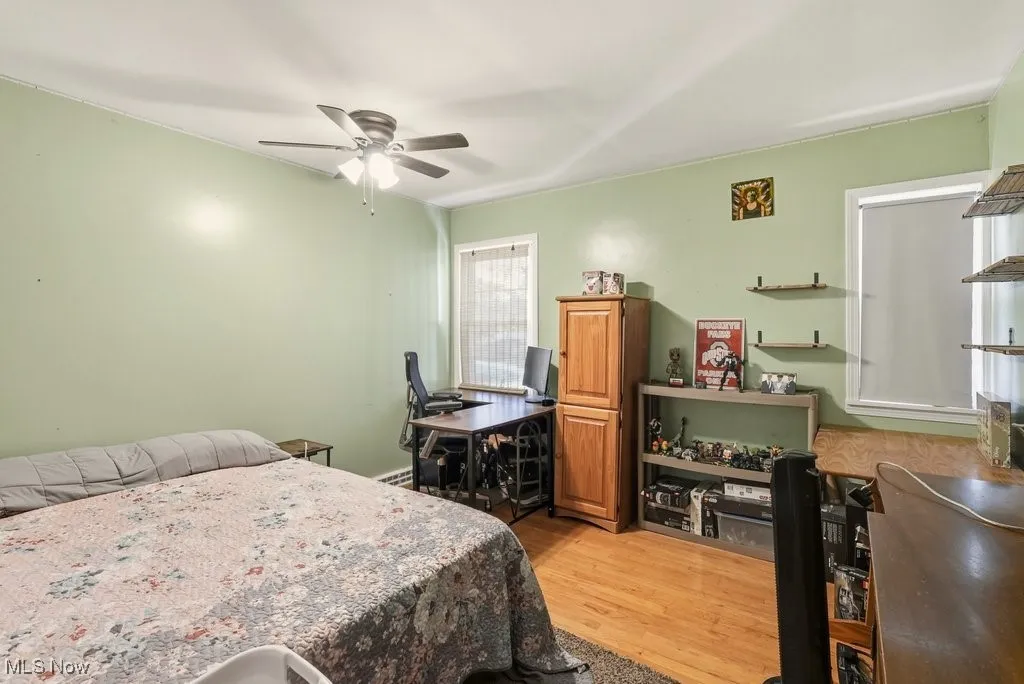 Bedroom with light wood-type flooring, a ceiling fan, and a desk