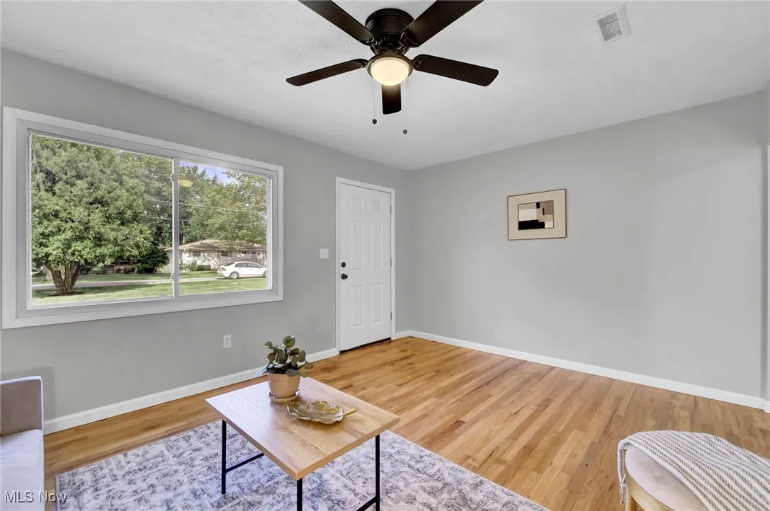 Living room with light wood-type flooring and ceiling fan