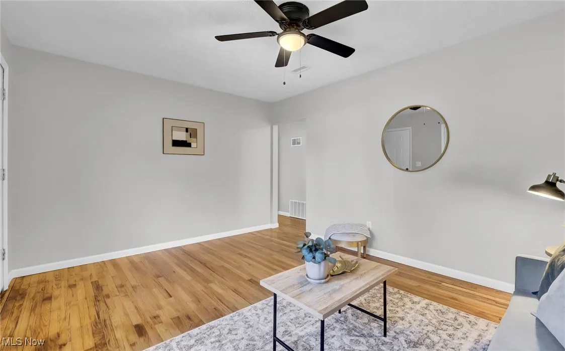 Living area featuring light wood finished floors and ceiling fan