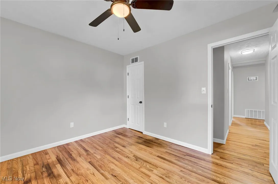 Unfurnished bedroom with light wood-style floors and ceiling fan