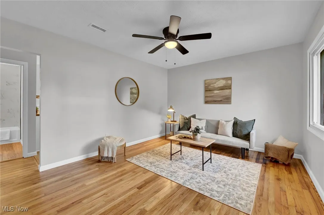 Living area featuring light wood-style floors and ceiling fan