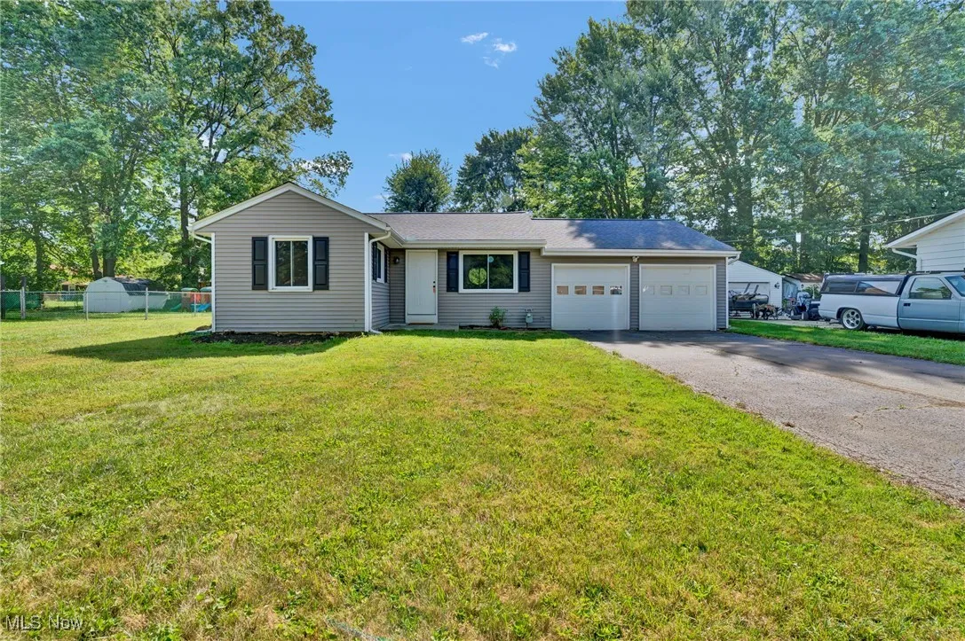 Single story home with driveway and a garage