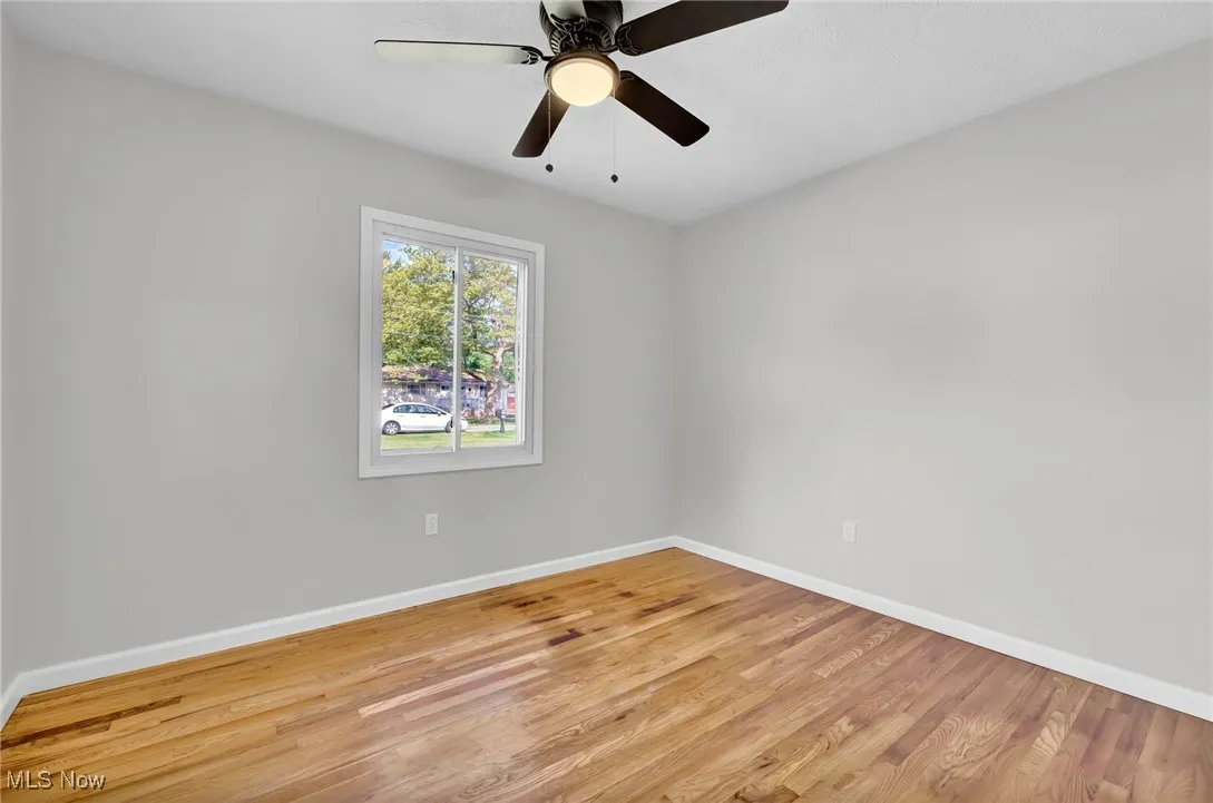 Empty room with light wood finished floors and ceiling fan