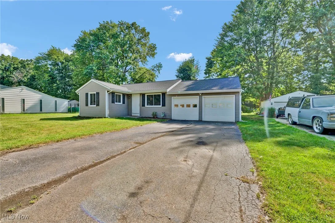 Ranch-style house with a front yard, driveway, and an attached garage