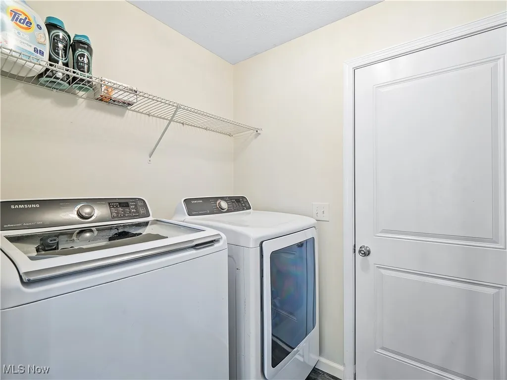 Washroom featuring independent washer and dryer and a textured ceiling