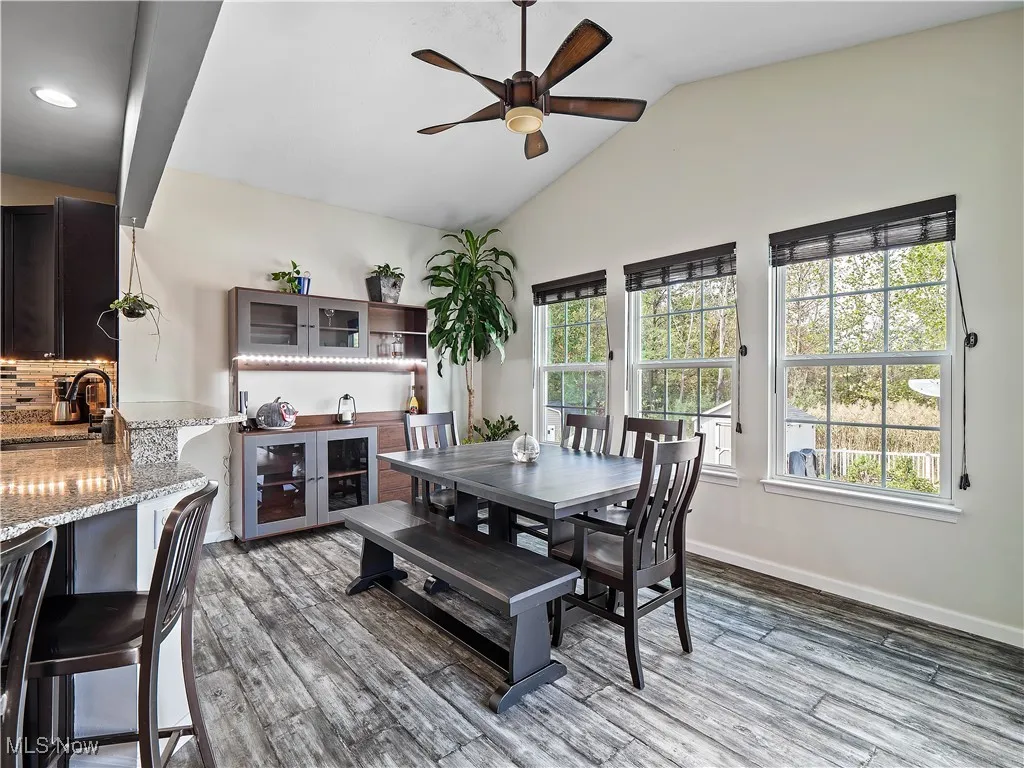 Dining space featuring vaulted ceiling, light wood-style flooring, and a ceiling fan