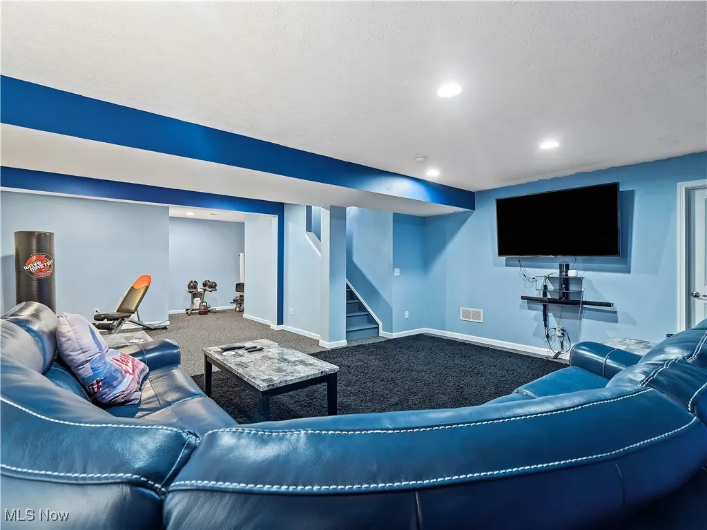Living room with stairway, recessed lighting, carpet, and a textured ceiling