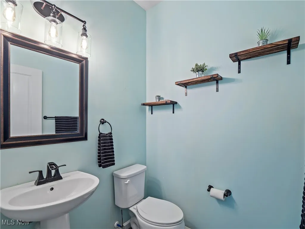 Half bath featuring toilet and a sink