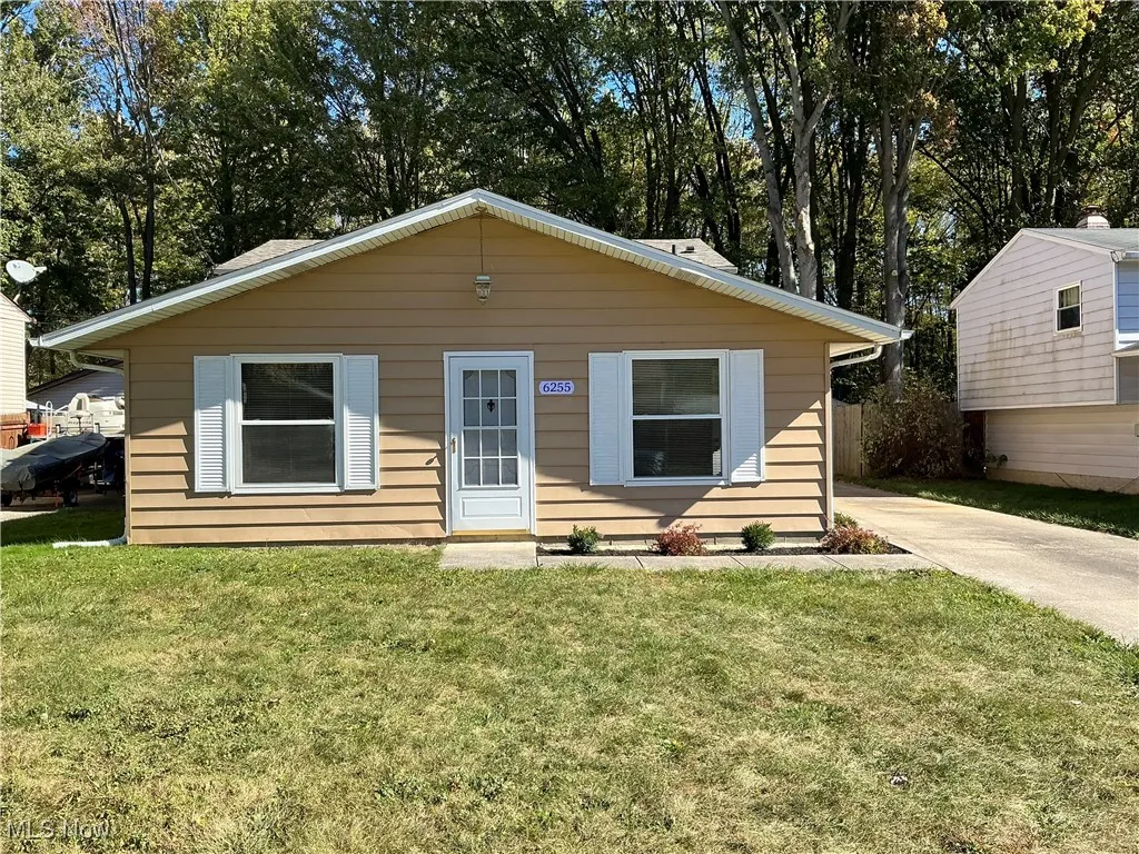 Bungalow with a front lawn and view of scattered trees