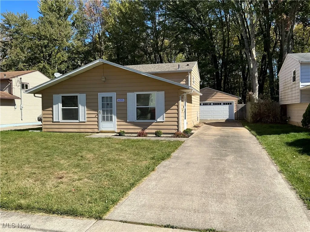 Bungalow-style home with view of wooded area and a garage