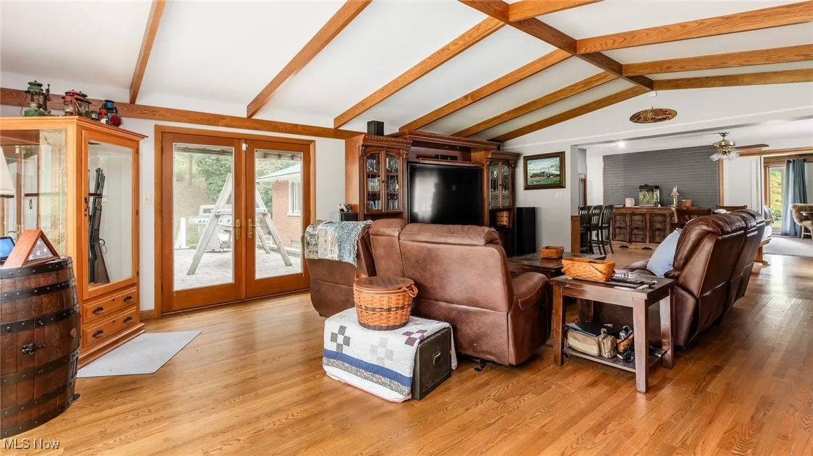 Living room with french doors, light wood-style floors, and a ceiling fan