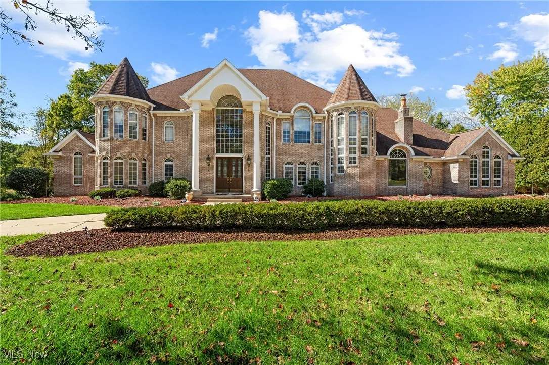 View of front facade featuring a front lawn and brick siding