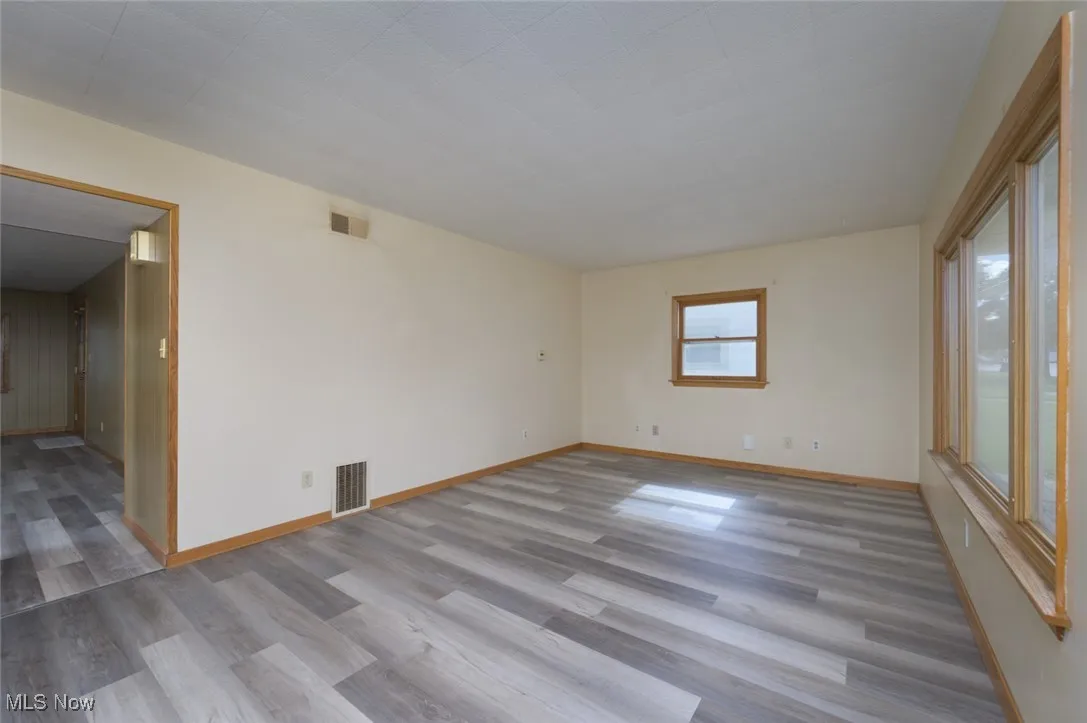 Spare room featuring light wood-style floors and baseboards