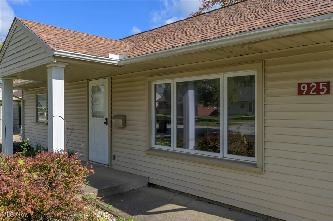 Entrance to property with roof with shingles