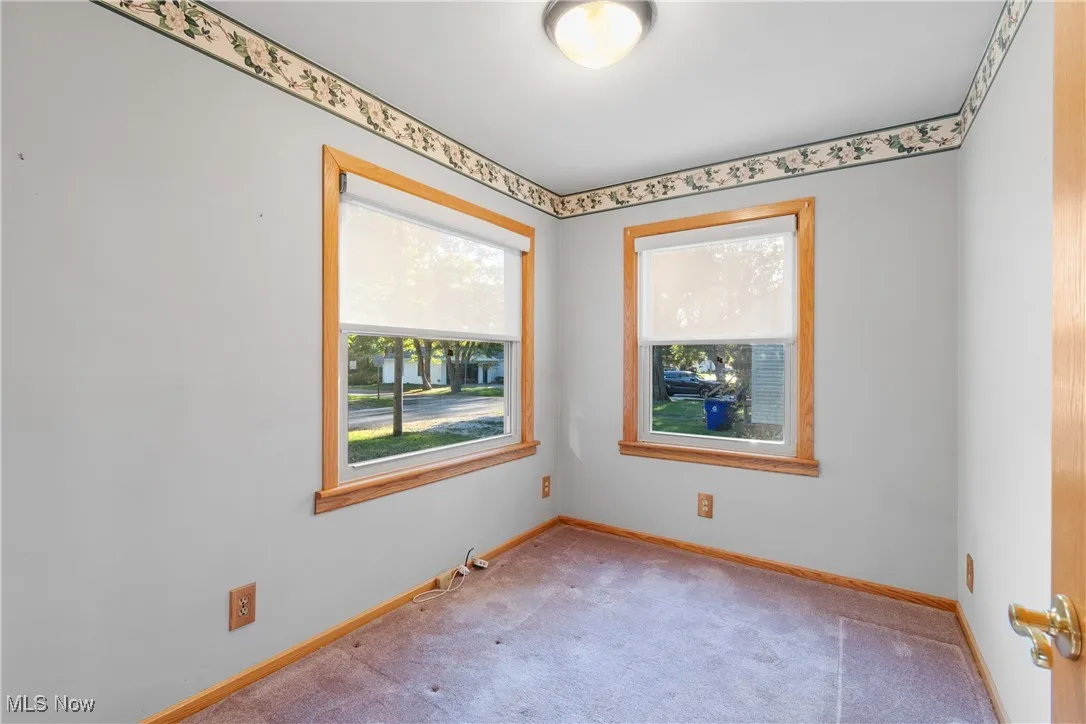 Spare room featuring carpet flooring and baseboards