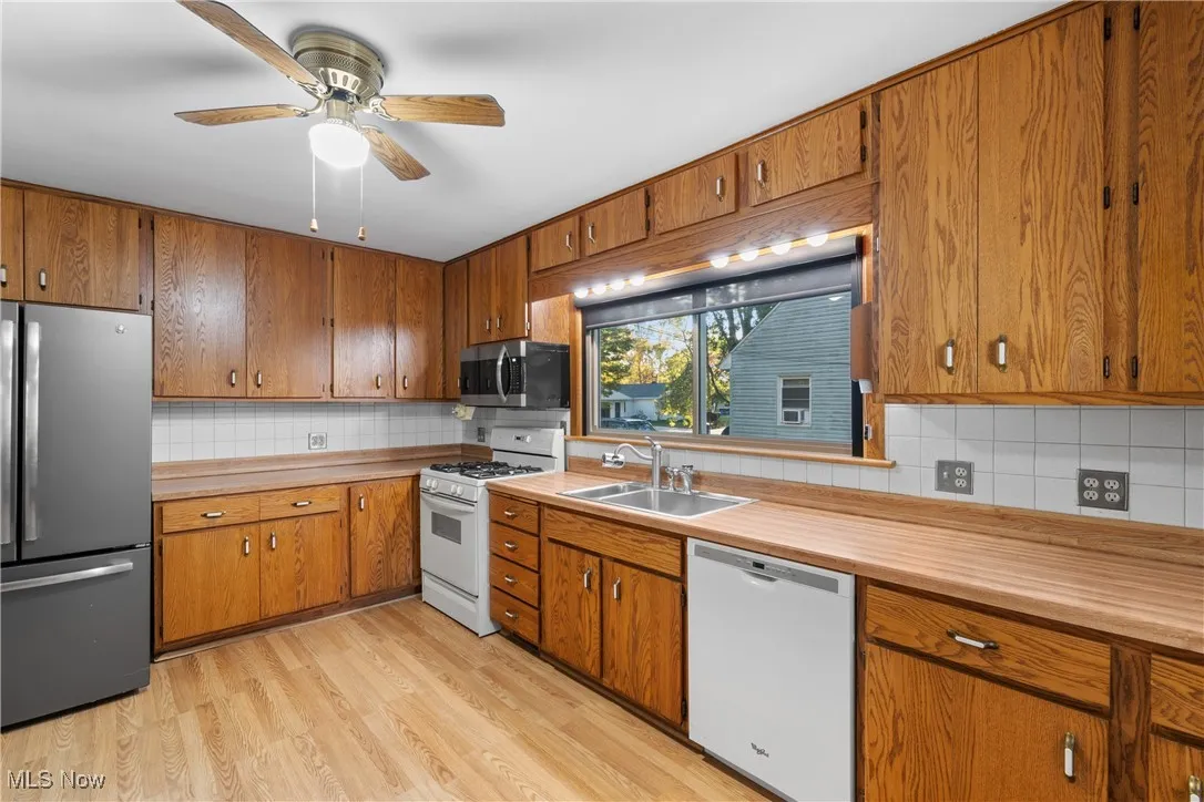 Kitchen featuring appliances with stainless steel finishes, backsplash, and brown cabinets