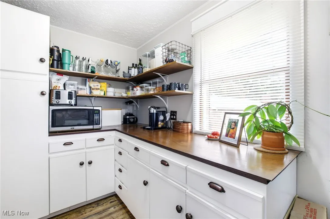 Pantry with dark countertops, cabinetry, and open shelves