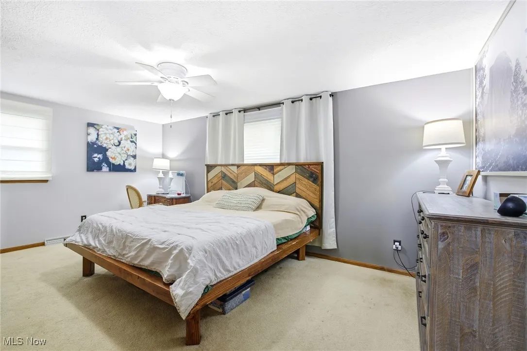 Primary bedroom featuring light colored carpet