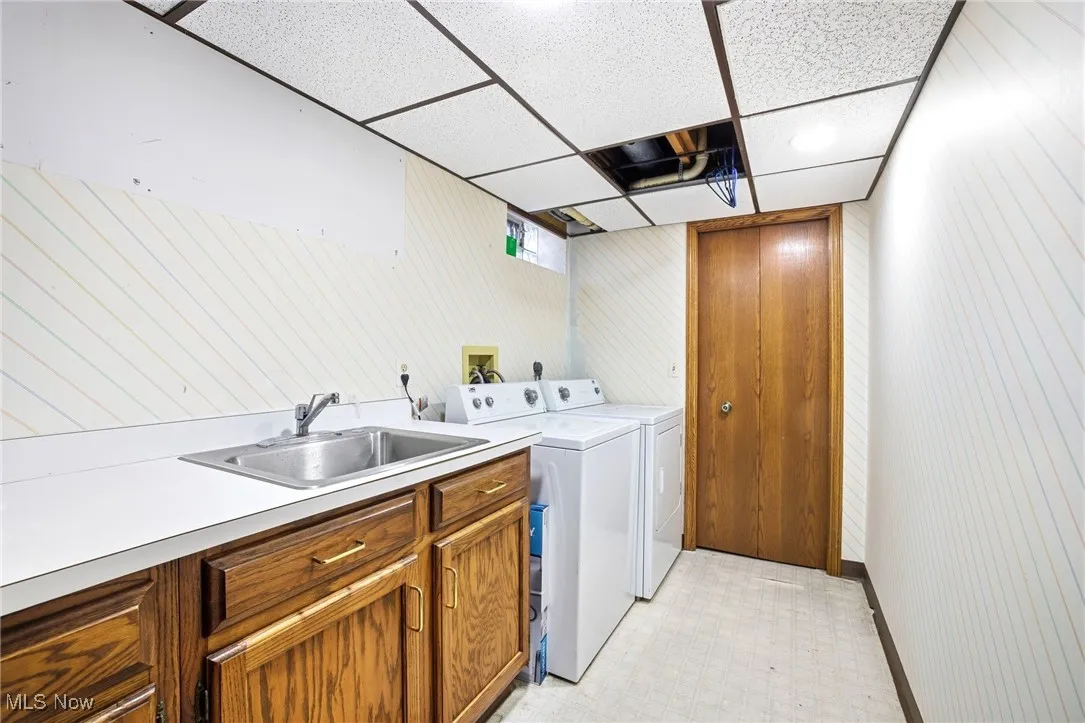 Laundry area featuring sink, cabinets and washer/dryer
