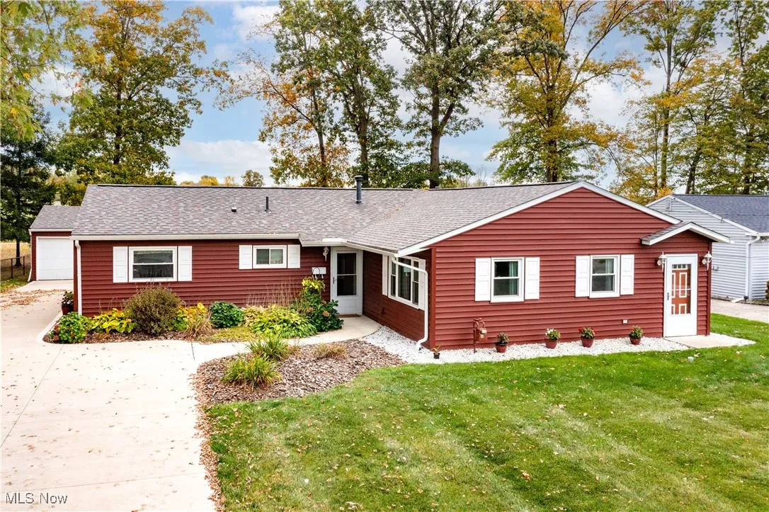 Ranch-style house with concrete driveway, front yard, and a two car detached garage