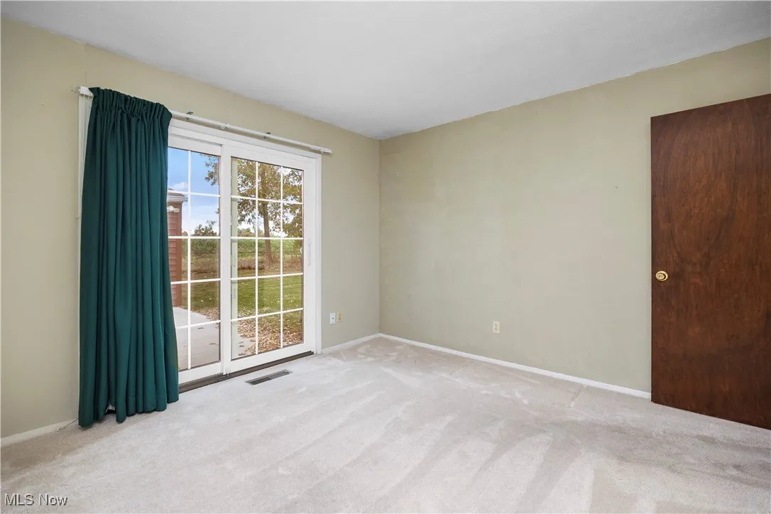 Bedroom two this view faces the back of the home and the sliding glass doors to the back yard