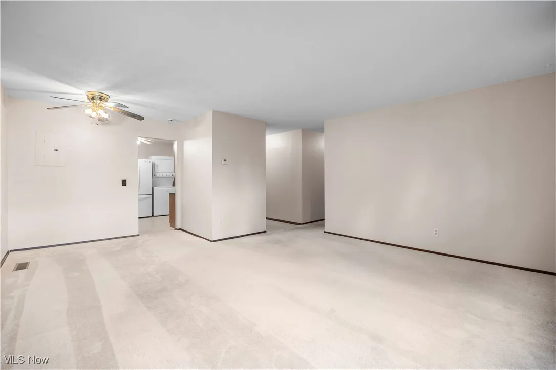 view from back of the living room facing the kitchen and foyer shows hall way to three of the five bedrooms