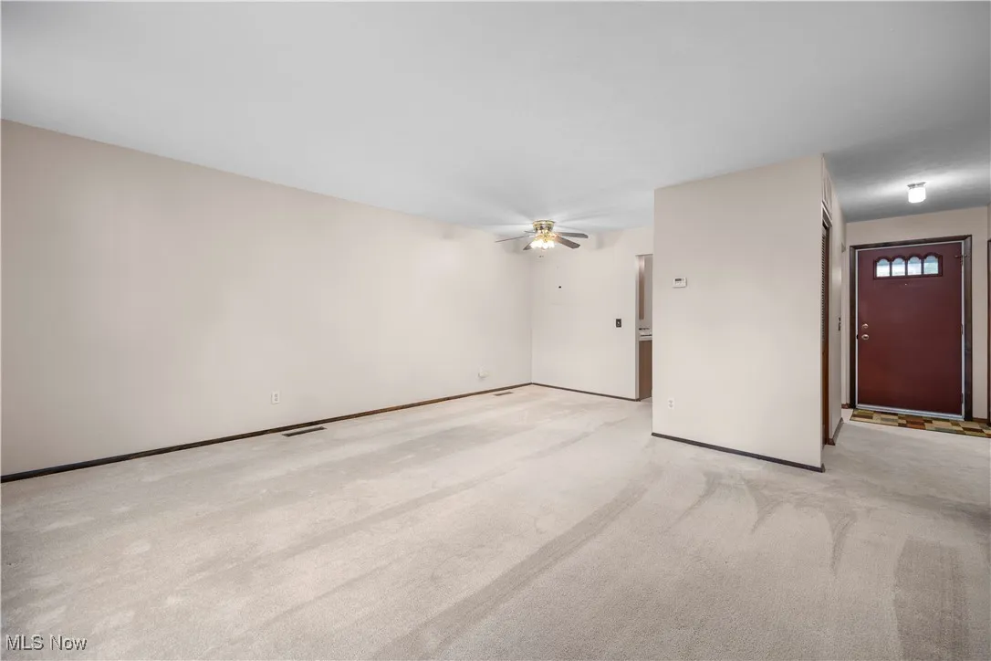 Living room with light carpet and ceiling fan