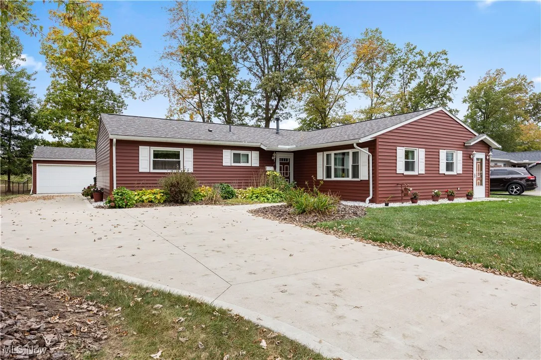 Ranch-style house with concrete driveway, front yard, and a two car detached garage