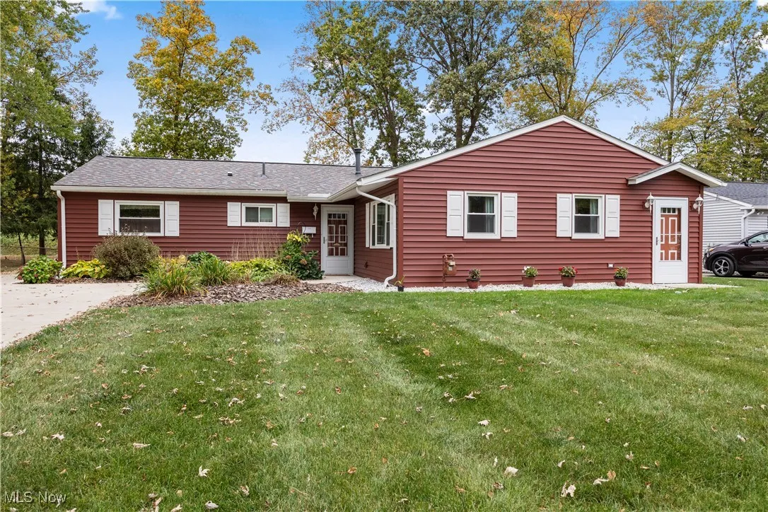 Ranch-style house with concrete driveway, front yard, and a two car detached garage