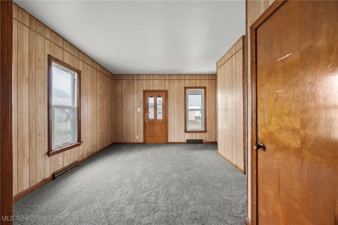 Spare room with wood walls and carpet