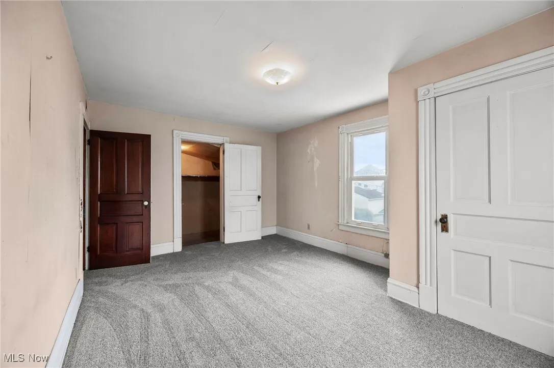 Unfurnished bedroom featuring light colored carpet and a spacious closet