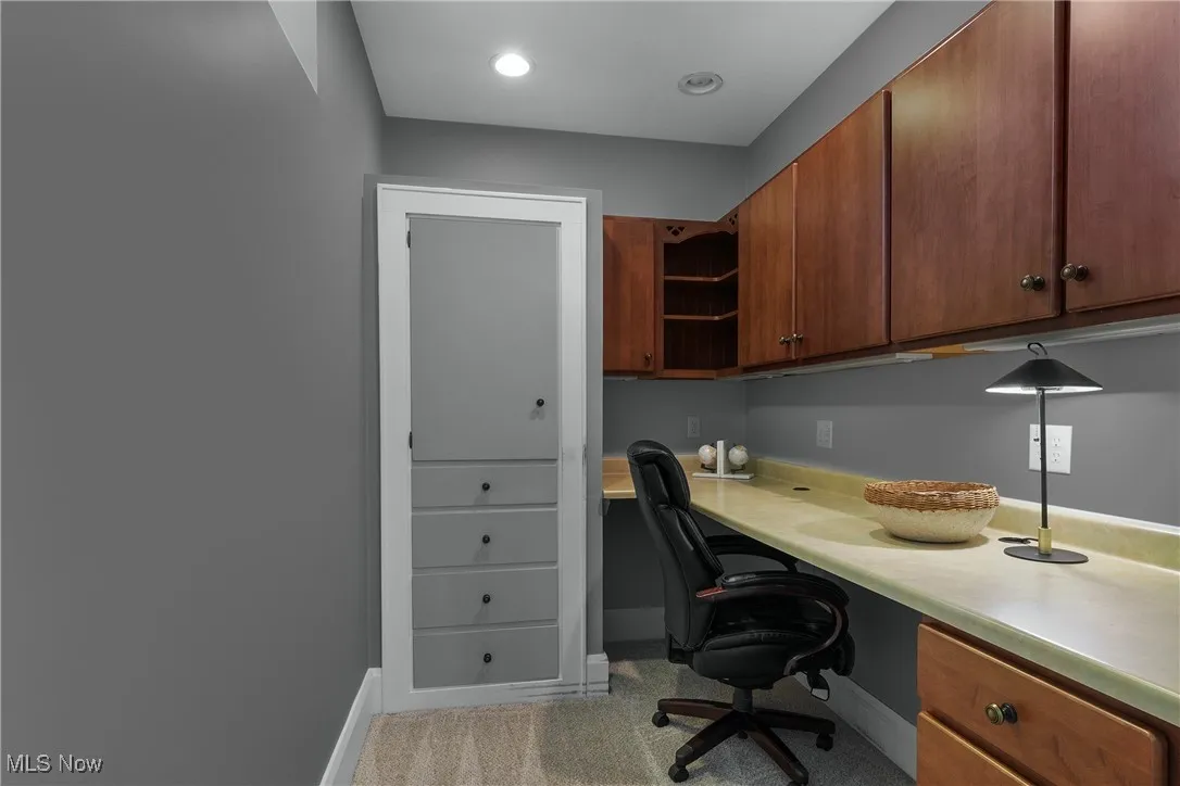 Office with built in study area, light colored carpet, and recessed lighting