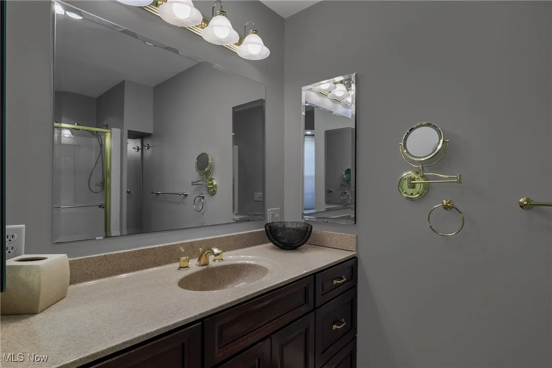 Full bathroom with vanity and a shower stall