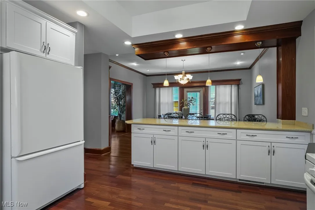 Kitchen with freestanding refrigerator, white cabinets, healthy amount of natural light, pendant lighting, and recessed lighting