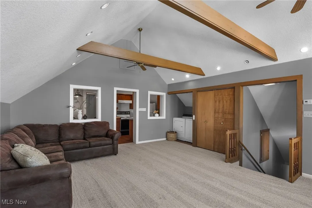 Carpeted living area with ceiling fan, recessed lighting, and a textured ceiling