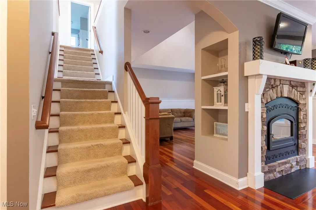 Stairs featuring built in features and a fireplace