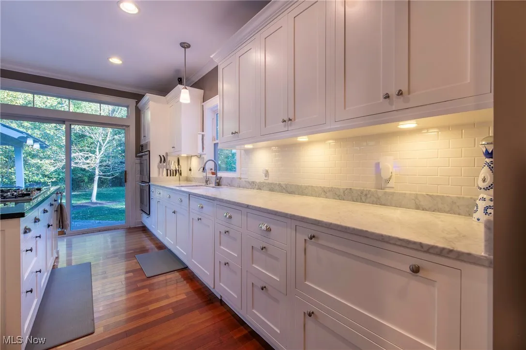 Kitchen with white cabinets, decorative backsplash