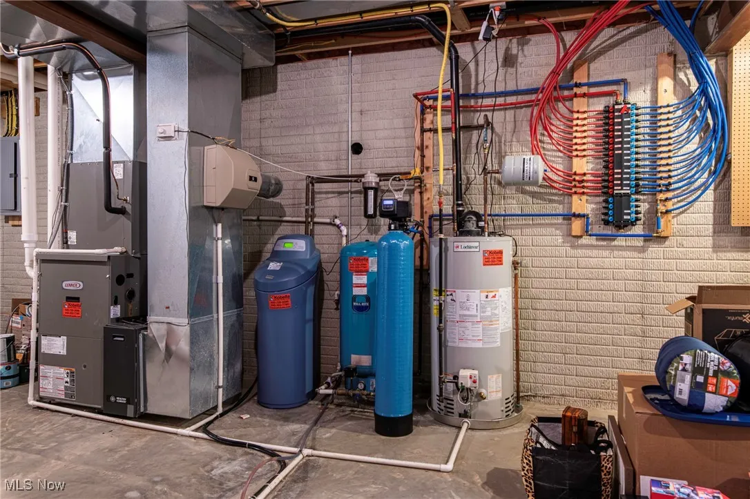 Utility room featuring heating unit and gas water heater and water softner