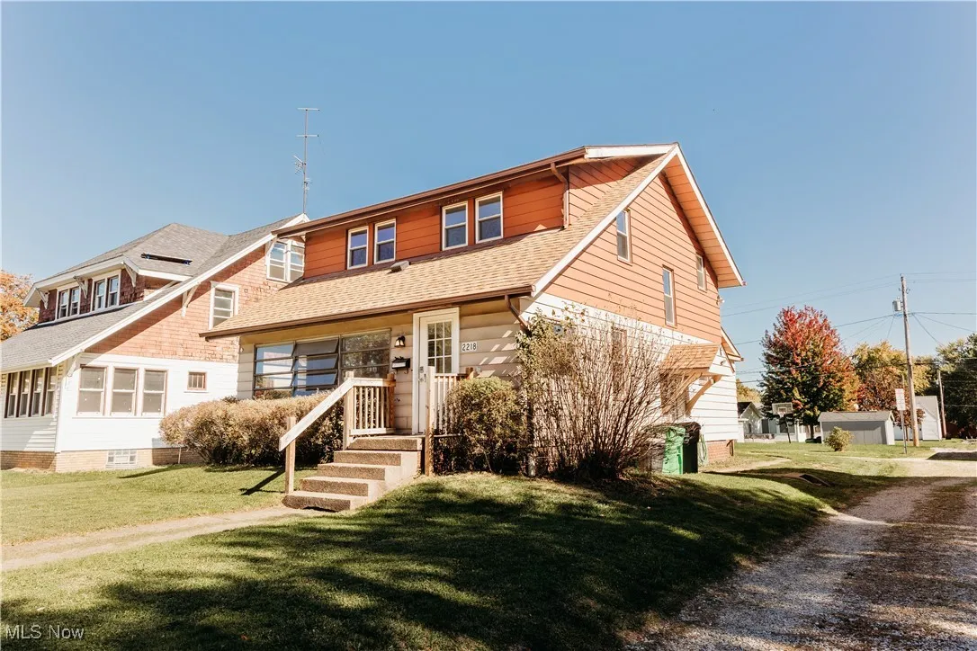 View of front of home featuring a front yard and roof with shingles